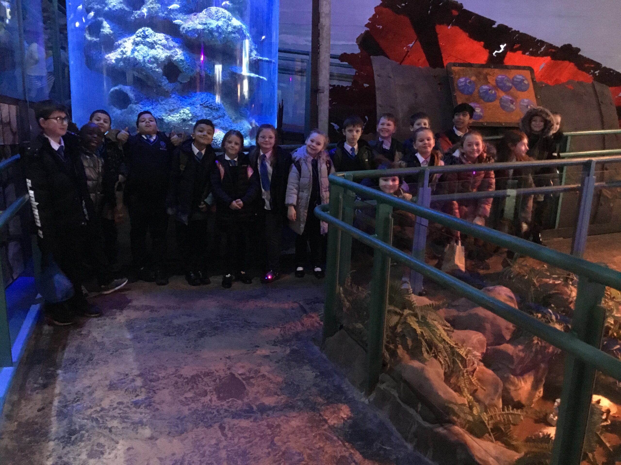 a group of students on a school trip in the aquarium